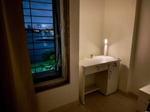 a bathroom with a candle on a sink next to a window at Lake View 2 BHK in Powai A in Mumbai +25 photos