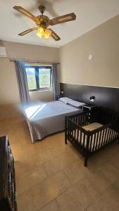 een slaapkamer met een bed en een plafondventilator bij Hotel Haití in San Miguel de Tucumán