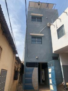 ein Gebäude mit einer blauen Tür und einer Treppe davor in der Unterkunft Torobali IMMO Studio 7- Modern & Bright- Central Bamako - WIFI & Solar Power in Bamako
