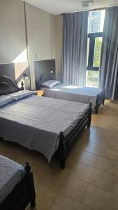 een slaapkamer met twee bedden en een raam bij Hotel Haití in San Miguel de Tucumán +3 foto's