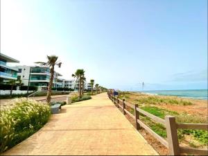 TamarisにあるBeachfront luxury apartmentのヤシの木と建物のある浜辺の歩道