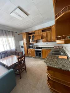 a kitchen with wooden cabinets and a table and a dining room at La perle de Benicarló 1 in Benicarló +10 photos