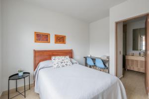 a bedroom with a bed and two blue chairs at Olivia's home in Zibata Queretaro in La Cañada