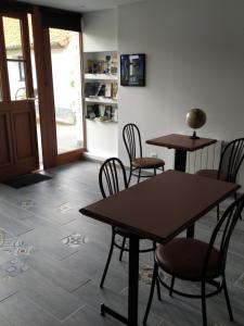 ein Raum mit zwei Tischen und Stühlen und einer Tür in der Unterkunft Entre Terre et Mer La Bichette in Guisy