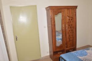 ein Schlafzimmer mit einer Holzkommode und einem Spiegel in der Unterkunft Torobali IMMO Studio 7- Modern & Bright- Central Bamako - WIFI & Solar Power in Bamako