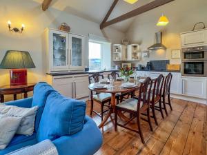 a kitchen and dining room with a table and a blue couch at 4 bed in Mindrum 86272 in Carham