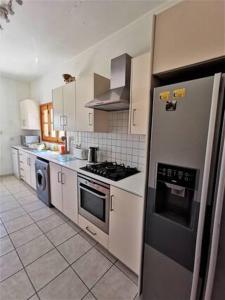 a kitchen with stainless steel appliances and white cabinets at Wedding Unique Villa in Larnaka