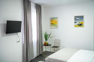 a bedroom with a bed and a tv and a chair at Most - Bitka za ranjenike na Neretvi in Jablanica