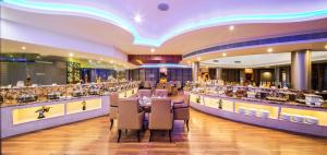 a restaurant with a long bar with tables and chairs at Clarks Exotica Convention Resort & Spa in Devanahalli-Bangalore