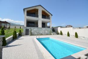 a villa with a swimming pool and a house at Dilijan Aqualin Villa - Heated pool, sauna and panoramic views in Dilijan