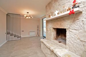 a large stone fireplace in a living room with red shoes at Dilijan Aqualin Villa - Heated pool, sauna and panoramic views in Dilijan