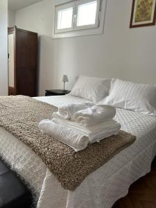 a bed with white towels on it with a window at Casa Kiros in Cangas de Morrazo