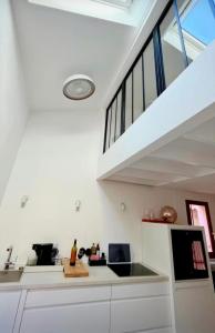 a kitchen with white cabinets and a staircase at Contemporary-style pavilion in Narbonne