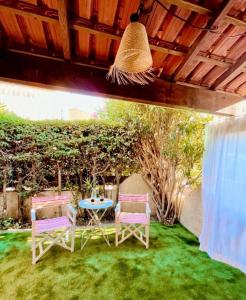 a patio with two chairs and a table in the grass at Contemporary-style pavilion in Narbonne