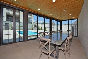 a dining room with a table and chairs and a pool at Dilijan Aqualin Villa - Heated pool, sauna and panoramic views in Dilijan