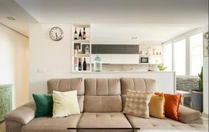 a living room with a couch with colorful pillows at Quarto com casa de banho privativo in Amadora +12 photos