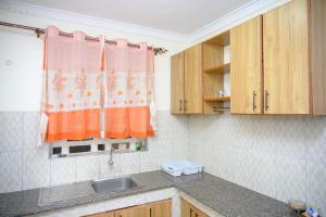 a small kitchen with a sink and wooden cabinets at SpringStone executive apartment A 11 in Ongata Rongai 