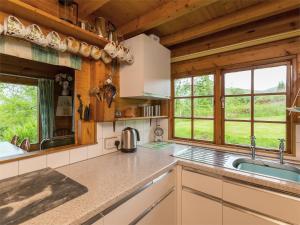 a kitchen with a sink and windows in a cabin at 2 Bed in Ardeonaig CA351 in Ardeonaig +30 photos