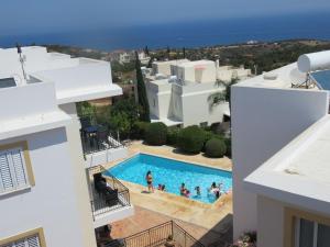 a group of people in a swimming pool in a building at Akamas Bayview Apartment in Neo Chorio