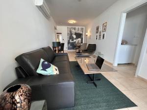 a living room with a couch and a glass table at Akamas Bayview Apartment in Neo Chorio