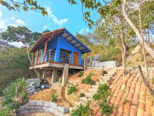 a blue house on top of a hill at Colina Escondida: monoAmbiente in San Juan del Sur