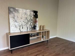 a television in a living room with a painting on the wall at Fonnagata in Åndalsnes