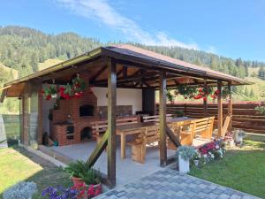 a wooden pavilion with a table and a fireplace at Casa Elena in Ceahlău