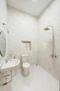 a white bathroom with a toilet and a sink at Essential Comfort Haven Homez in Ago Palace in Lagos