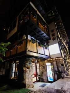 a building with a balcony on top of it at night at The Hill in Veliko Tŭrnovo