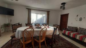 a dining room with a table and chairs and a couch at Casa Elena in Ceahlău