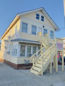 a yellow building with a staircase in front of it at Shore Beach Houses - 38 B Lincoln Ave in Seaside Heights