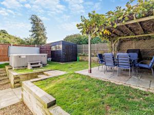 a backyard with a table and chairs under a pergola at 2 Bed in Cromer 29556 in Cromer