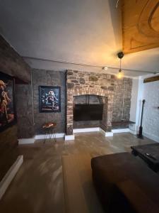 a living room with a stone fireplace with a table at Stylish Industrial 1 Bed in Bristol