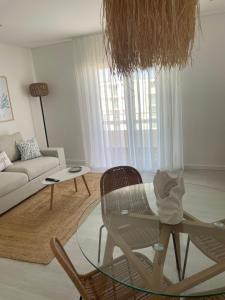 a living room with a glass table and a chair at Pêra doce in Armação de Pêra