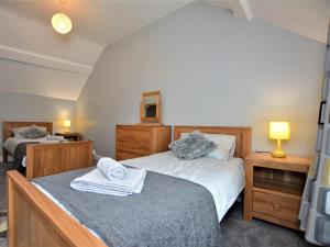 Un dormitorio con dos camas y dos mesitas de noche. en 4 Bed in Conwy 66510, en Llanrwst