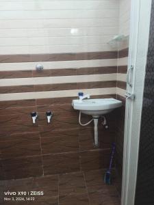 a bathroom with a sink and wooden walls at Raja Residency & Room stay in Papanāsam