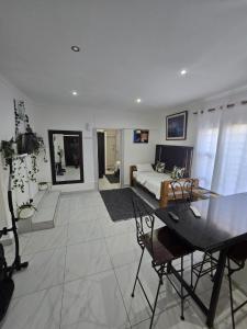 a living room with a bed and a table and chairs at Oasiselfcatering guest house in Kimberley