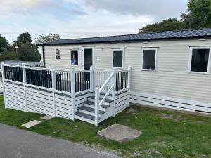 a white mobile home with a white railing at HoneyBees At Glade 17 in Bucks Mills