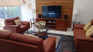 a living room with couches and a flat screen tv at New house with pool, excellent, 3 bedrooms in Pazulco