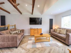 a living room with two couches and a tv at Mallard Cottage in Penrith