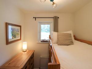 a bedroom with a bed and a table with a lamp at Mallard Cottage in Penrith +42 photos