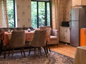 a kitchen and dining room with a table and chairs at Кюнгют Гостевой дом in Sheki
