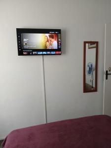 Elle comprend une télévision à écran plat suspendue sur un mur blanc. dans l'établissement Brachil 1, à Búzios
