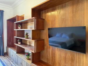 a bedroom with a bed and a large flat screen tv at Casa Vega in Cuenca