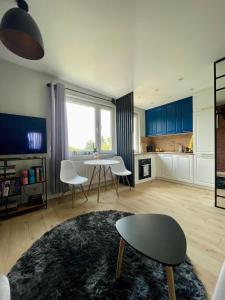 a living room with a table and chairs and a kitchen at Stylish apartment by the castle in Malbork