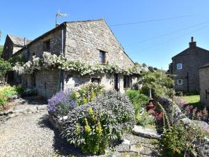 an old stone house with flowers in front of it at 1 Bed in Richmond 44401 in Reeth
