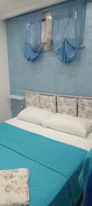 a bed in a room with blue walls and curtains at Green Garden da Virna 2 in Torre Annunziata +35 photos