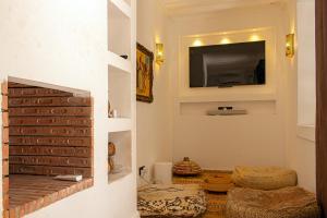 een woonkamer met een televisie aan de muur bij Riad Dar Ben Slimane in Marrakesh