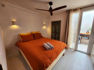 - une chambre avec un grand lit orange et une fenêtre dans l'établissement La Casa Rosie, charme paisible à Palavas les Flots, à Palavas-les-Flots