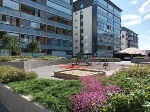 a playground in front of a tall building at Lovely new city apartment all amenities in Seinäjoki